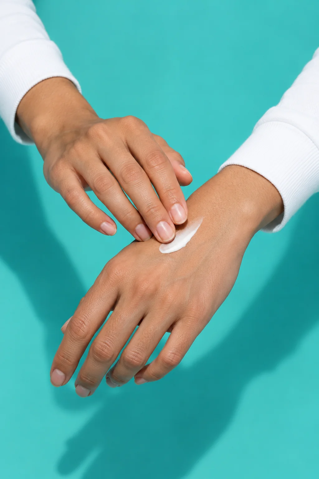 Hand applying cream to the back of a wrist